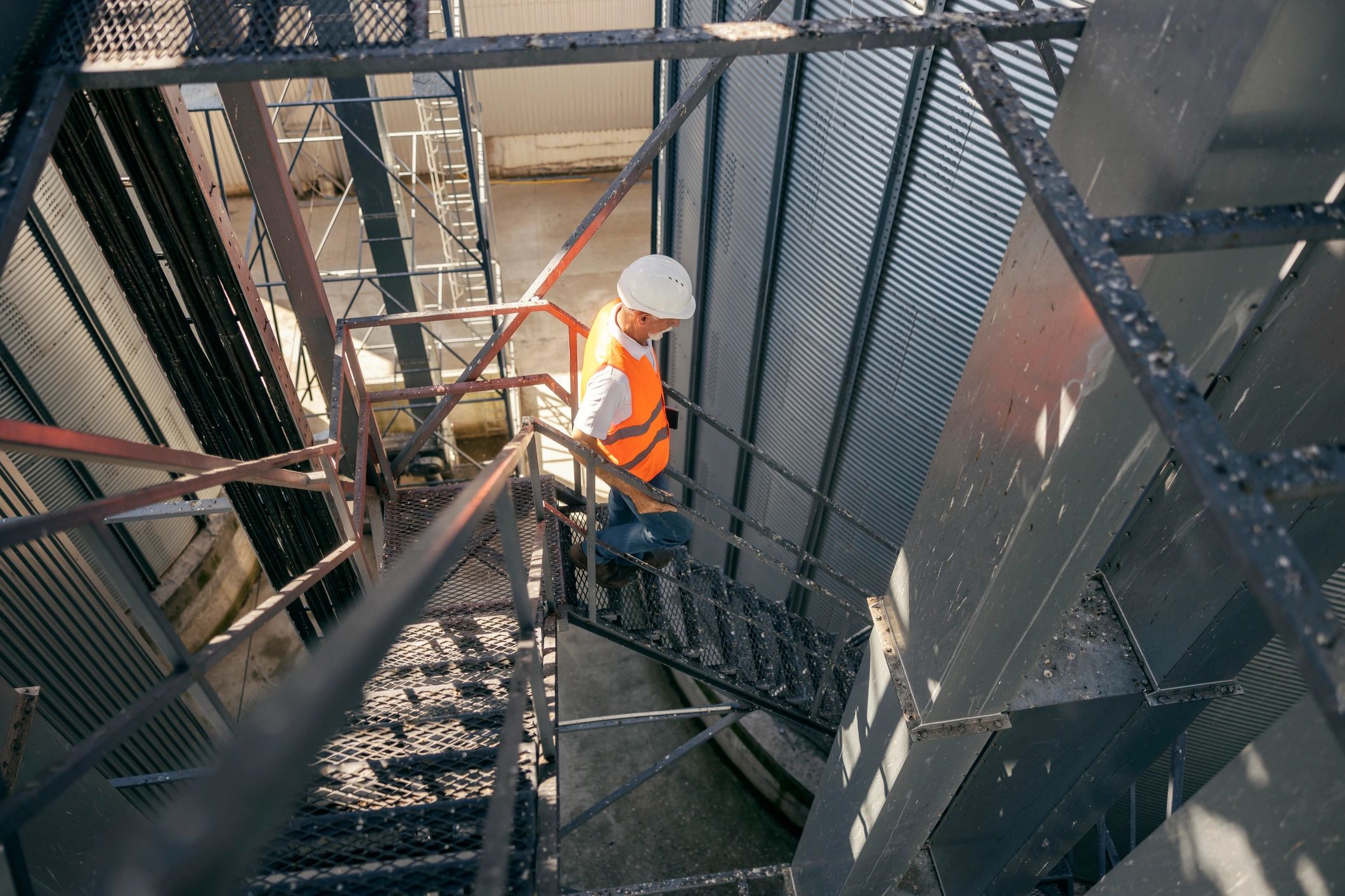 Industrial worker climbing stairs at an outdoor facility